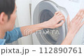 A man in an apron doing laundry 112890761