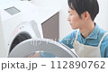 A man in an apron doing laundry 112890762