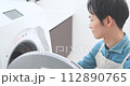 A man in an apron doing laundry 112890765