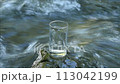 Drinking water poured into a glass and a mountain stream 113042199
