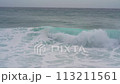 Waves on the sea. A foamy wave rolls onto a sandy shore covered with clean golden sand 113211561