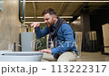 Funny man buyer imitates drumming while choosing ceramic toilet bowl for WC room 113222317
