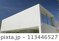 House building with many windows against a blue sky backdrop 113446527
