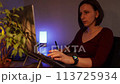 Young woman using a laptop and graphic tablet at home in the evening 113725934