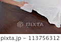Wiping dust and hair off the floor with a wet wipe, floor cleaning, picking up hair 113756312