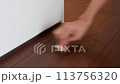 Wiping dust and hair off the floor with a wet wipe, floor cleaning, picking up hair 113756320