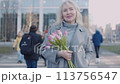 A senior woman with flowers in a big city 113756547