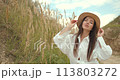 Woman dressed in country style posing in the summer field 113803272