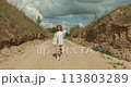 Young Caucasian woman dressed in cowboy style in the summer field 113803289