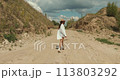 Young Caucasian woman dressed in cowboy style in the summer field 113803292
