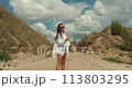 Young Caucasian woman dressed in cowboy style in the summer field 113803295