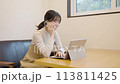 Young woman using a computer and talking on the phone 113811425
