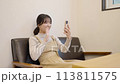 Young woman making a video call on her smartphone 113811575