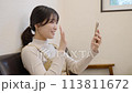 Young woman making a video call on her smartphone 113811672