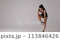 Slow motion of young woman wearing sports bra shorts taking off resistance band 113846426
