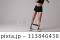 Young slim caucasian woman performs banded leg lifts 113846438