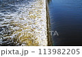 The flow of water from the outlet of an artificial dam 113982205