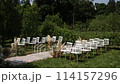 a beautiful arch for a wedding ceremony in a park with chairs	 114157296