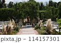 a beautiful arch for a wedding ceremony in a park with chairs	 114157301