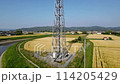 A mobile phone tower standing in a rural landscape. A pan-up video of the entire tower. 114205429