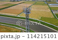 Aerial panning video of a mobile phone base station tower standing in a rural landscape 114215101