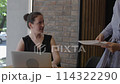 Discussion table businesswomen discuss partnership and collaboration one of them presenting fresh financial report. Partnership resonates throughout their conversation Cooperation and partnership. 114322290