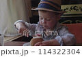 In cafe table child boy in cute hat sitting and eating dessert cake. Sweet dessert cake sheer delight tasty blend of flavors Tasty sweet dessert cake pure joy of savoring decadent treat. 114322304