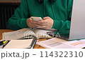 Table with laptop study materials student typing messages chatting in phone. Chatting offers brief diversion during study sessions balance between academic focus social interaction with chatting. 114322310