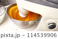 A pastry chef mixes eggs with sugar in a mixer to make cream. 114539906