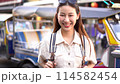 Young Asian woman smiling at camera while traveling backpacker in Khaosan Road outdoor market in Bangkok, Thailand. High quality 4k footage 114582454
