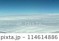 旅客機の窓からみた青空と雲海・雲海が流れていくシーン 114614886