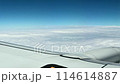 航空機の窓から眺めた飛行機の翼と美しい雲海のシーン 114614887