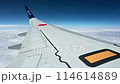 航空機の窓から眺めた飛行機の翼と美しい雲海のシーン 114614889
