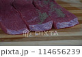 Man in black gloves gently applying pepper on the raw meat slices 114656239