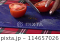 Woman's hands using kitchen knife cutting fresh tomato on plastic cutting board. Healthy eating. Sliced tomato. 114657026