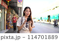 Smiling Asian woman traveller backpacker using application of taxi service app on smart phone. High quality 4k footage 114701889