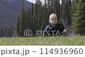Baby boy playing outside on green grass in lush Canadian Nature. 114936960