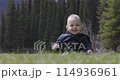 Baby boy playing outside on green grass in lush Canadian Nature. 114936961