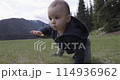 Baby boy playing outside on green grass in lush Canadian Nature. 114936962