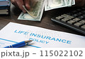 Life insurance form and hands counting out money. 115022102