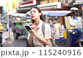 Young Asian woman getting lost and using map on a mobile phone while traveling and backpacker in Khaosan Road outdoor market in Bangkok, Thailand 115240916