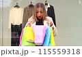 Happy young womanlooking at the shopping bags they have bought. 115559318