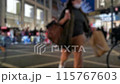 A city street at night with a blurred effect showing people, cars, buildings and lights. 115767603