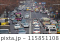Time Lapse blurred video of a bustling street with numerous cars, buses, trucks and pedestrians. 115851108