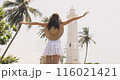 Joyful Woman Embracing the Sun at Galle Fort Lighthouse in Sri Lanka 116021421
