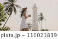 Woman in White Dress Exploring Galle with Camera in Hand 116021839