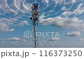 Mobile telecommunication cell tower with transmit telecommunication signal. 4G 5G mobile network. Telecommunication tower against a blue sky with clouds transmitting a luminous signal around it. 116373250