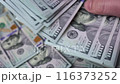 Man's fingers count a thick stack of American dollars. Concept of currency exchange, riches, money savings, profit, saving paper money. 116373252