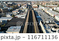 A city street with a train running through it 116711136