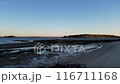 A beach with a calm ocean and a clear blue sky 116711168